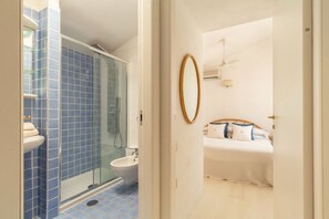 A bathroom with a glass shower enclosure, a white sink, and a bidet. - BLUE BAY HOME just few steps from the bay of Porto Luna (Villasimius)