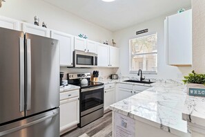 Casa de ciudad, varias camas, patio, vista al jardín (Howard’s Vacations at Regal Palms) | Cocina privada | Refrigerador, microondas, horno y parrilla de estufa 
