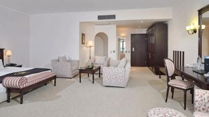 A hotel room with a bed, two armchairs, a sofa, a dining table, and a mirror. - Melia Grand Hermitage (Golden Sands)