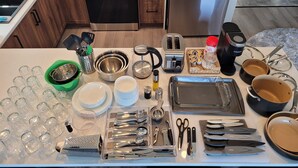 A kitchen with modern appliances, including a stove, oven, and refrigerator. There are various kitchen utensils and cookware on the counter.