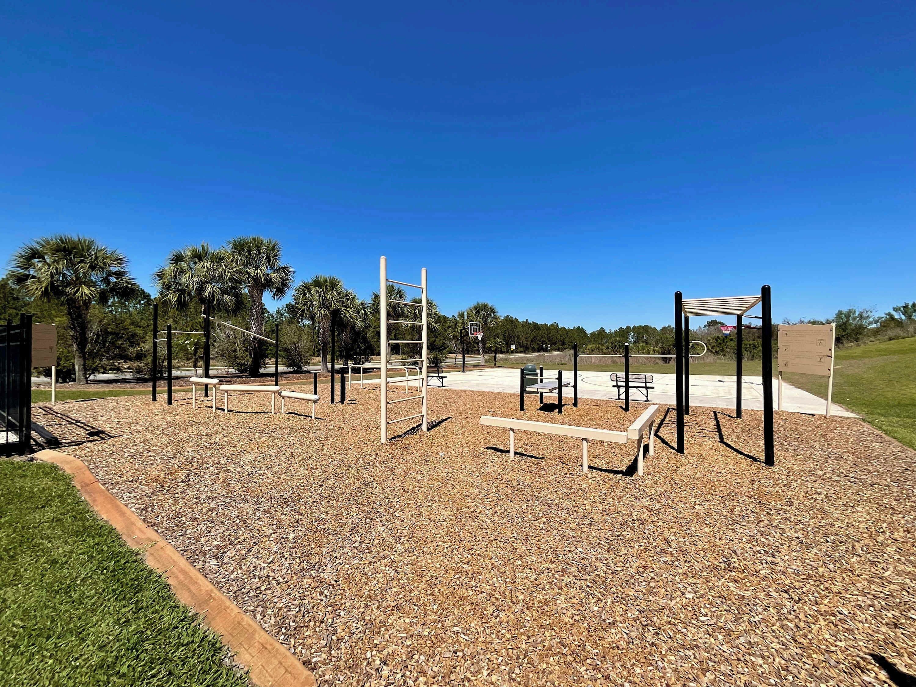 A playground with various exercise equipment, including a ladder, bars, and a basketball hoop.