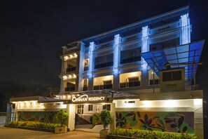 A hotel with a modern facade, a prominent entrance, and a mural on the wall. - Cannan Residency (Puducherry)