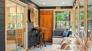 A cozy room with a chessboard, a sofa, and a window with a view of greenery. - The Horseshoe Hideaway Lake Harmony Cabin w/ Hot Tub & Game Porch (Lake Harmony)