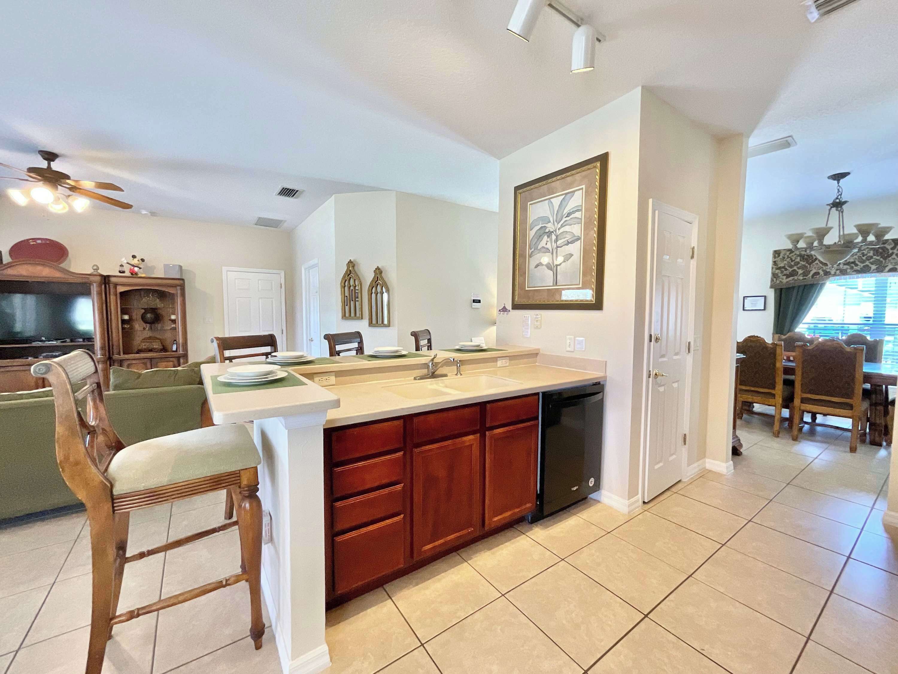 A modern kitchen with a central island, wooden cabinets, and a dining area with a table and chairs.