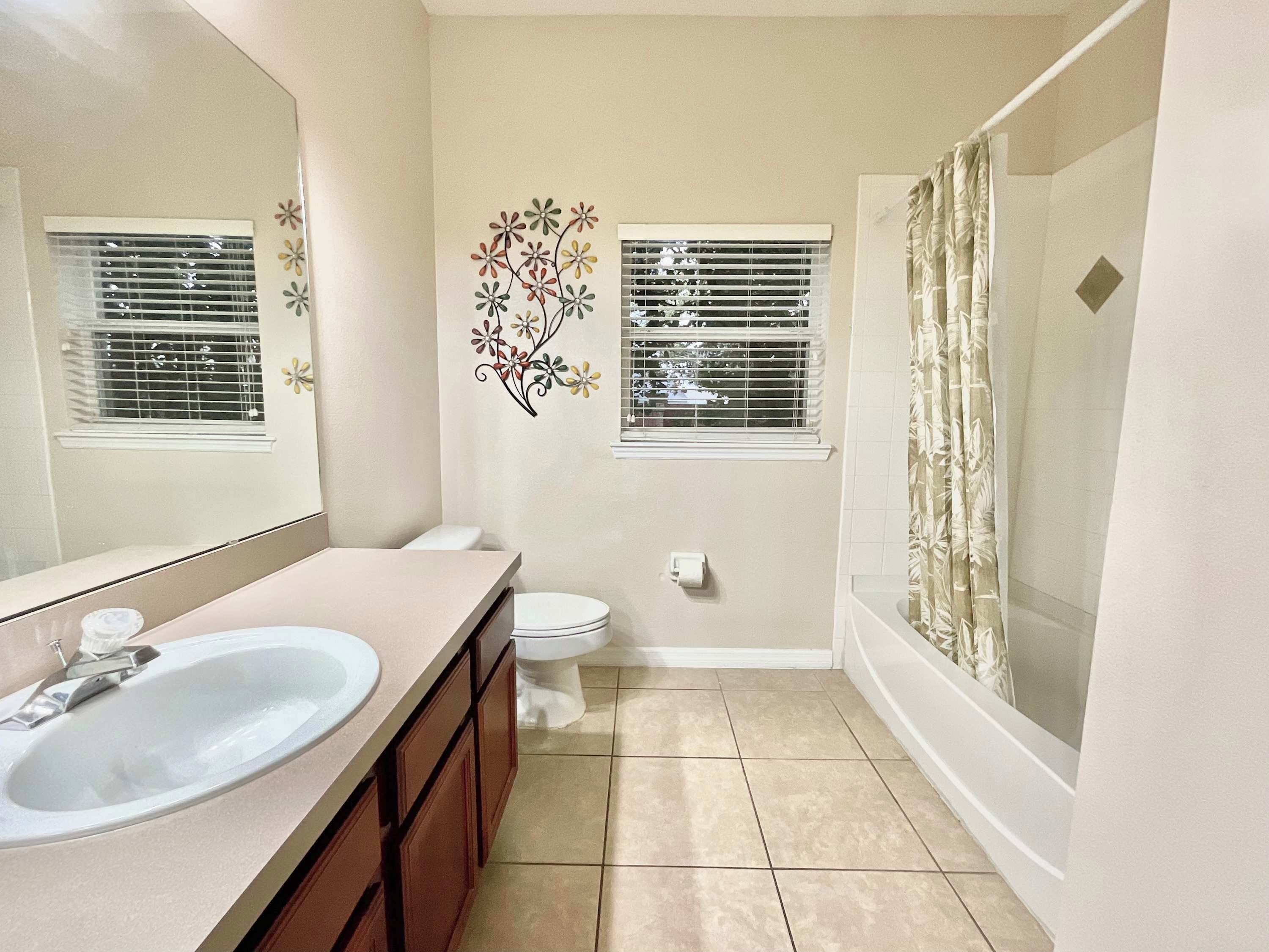 A bathroom with a sink, toilet, and shower.