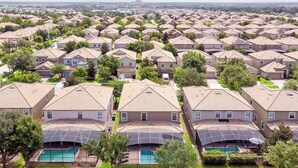 A residential area with multiple houses, each with a swimming pool and solar panels. - Mickeys Mansion At Championsgate (Davenport)