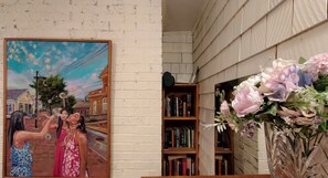 A room with a brick wall, a bookshelf, and a painting. - Relaxing Harwich retreat with beautiful back yard/ pet friendly! (Harwich)
