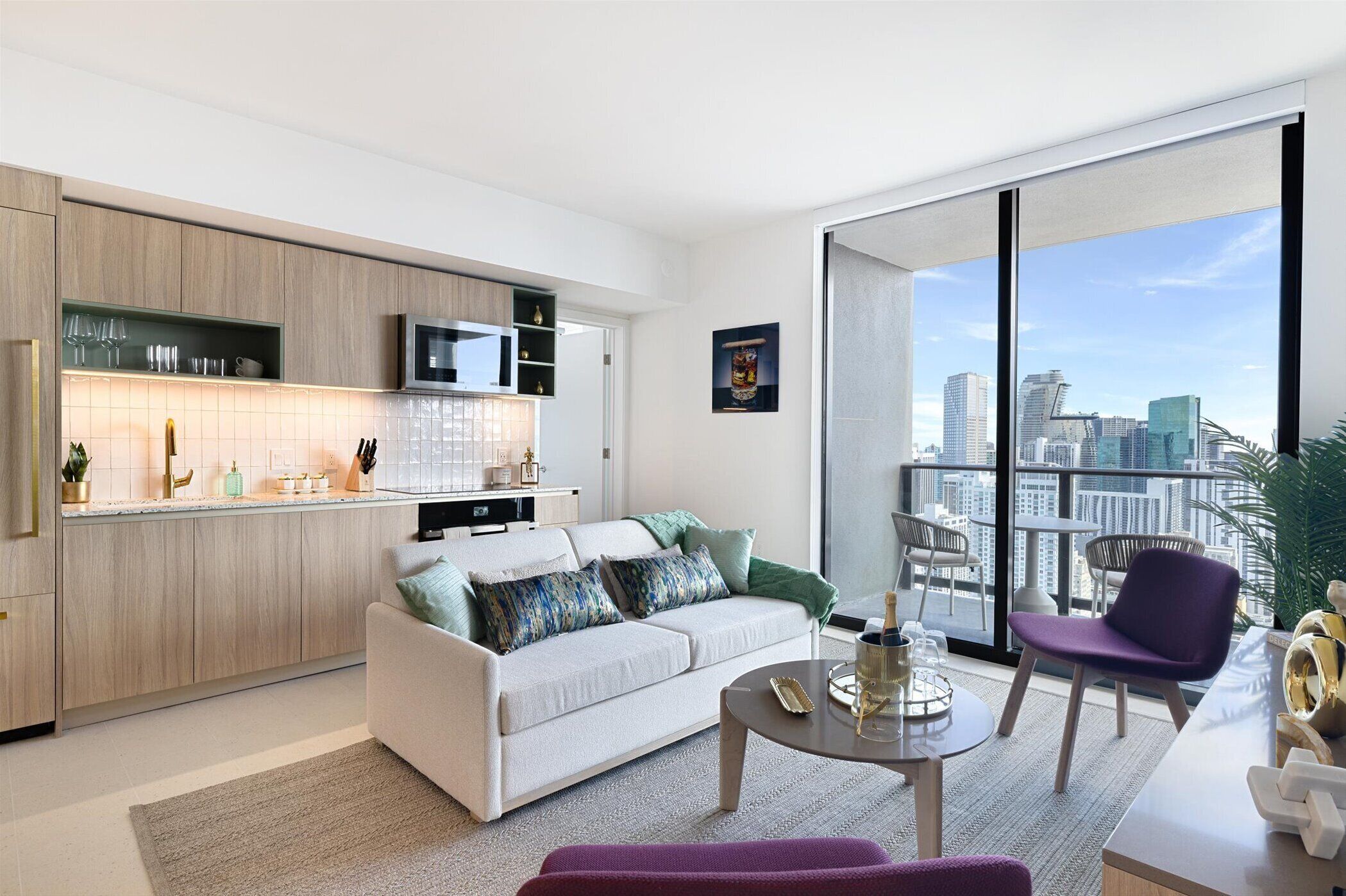 A modern living room with a sofa, coffee table, and a balcony with a city view.