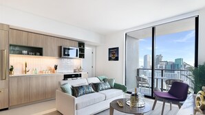 Un salon moderne avec un canapé, une table basse et un balcon offrant une vue sur la ville.