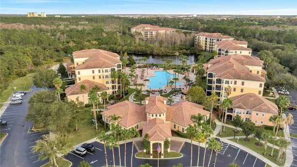 A resort with multiple buildings, a central swimming pool, and a parking area. - Minutes to Magic (Orlando)