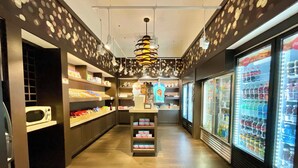A narrow corridor with shelves stocked with snacks and a refrigerator filled with beverages. - Minutes to Magic (Orlando)