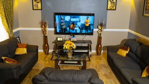 Un salon avec deux canapés, une table basse et un téléviseur.