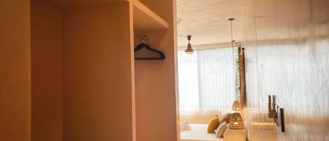 Una habitación de hotel con una cama, una lámpara colgante y una mesita de madera.