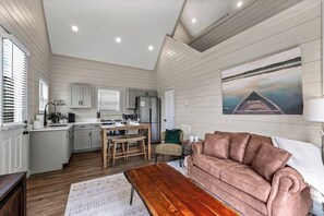 A cozy living room with a wooden coffee table, a sofa, and a painting on the wall. - Cozy Current Lake Cabin! +Pet Friendly +Game Loft! (Sevierville)