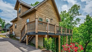 A two-story wooden house with a balcony and a staircase leading to the upper floor. - Cozy Current Lake Cabin! +Pet Friendly +Game Loft! (Sevierville)