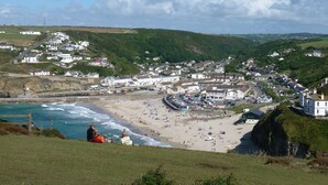 Une ville côtière avec une plage, des maisons et une falaise.