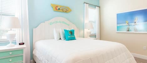 A bedroom with a bed, a nightstand, a dresser, and a painting on the wall.