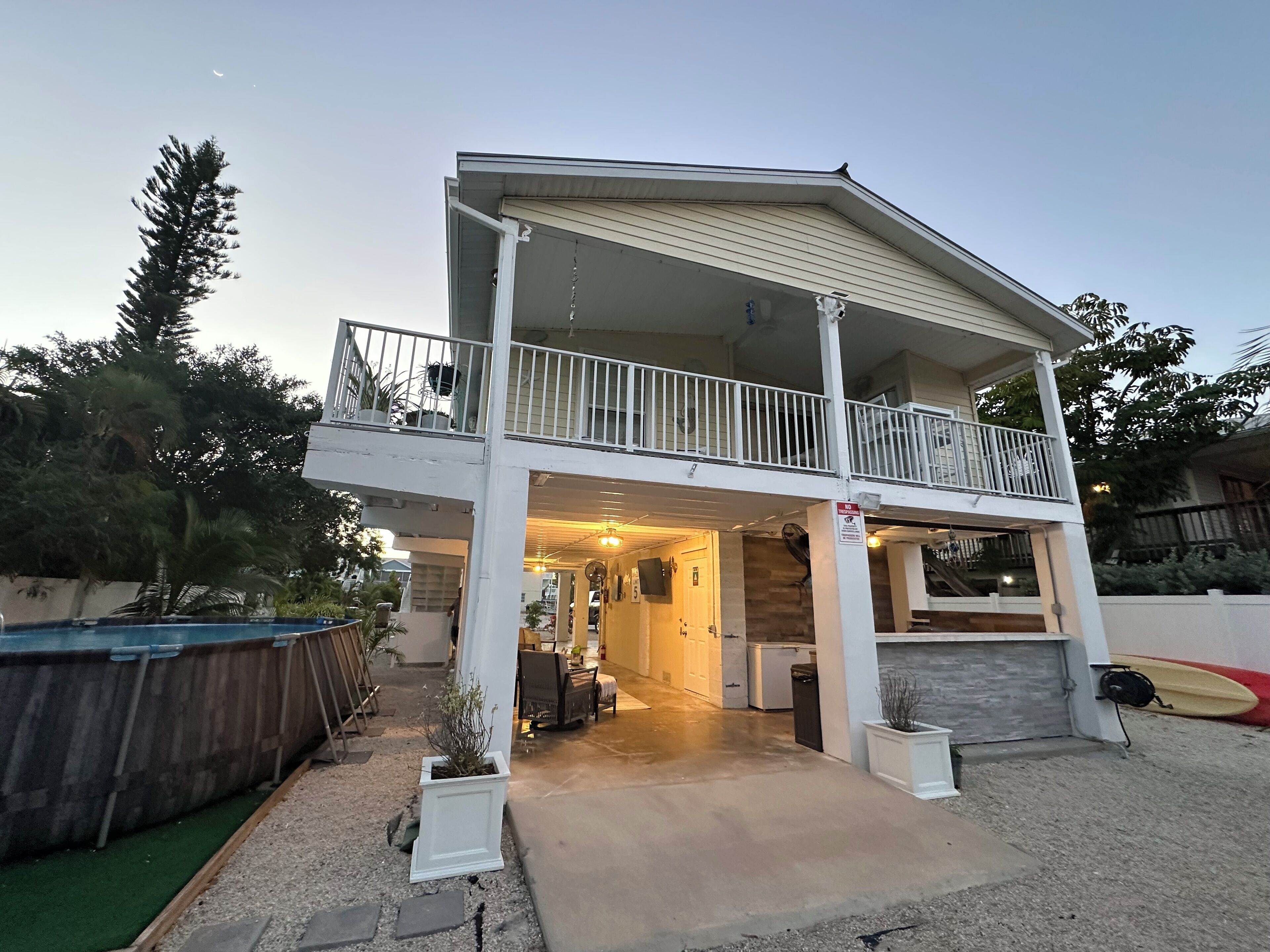 Ein zweistöckiges Haus mit Balkon, Veranda und Garage.