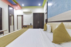 A hotel room with a large bed, a desk, an air conditioner, and a wardrobe. - HOTEL AIRPORT VIEW (Jaipur)
