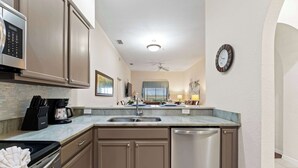 A modern kitchen with a dishwasher, a coffee maker, and a microwave.