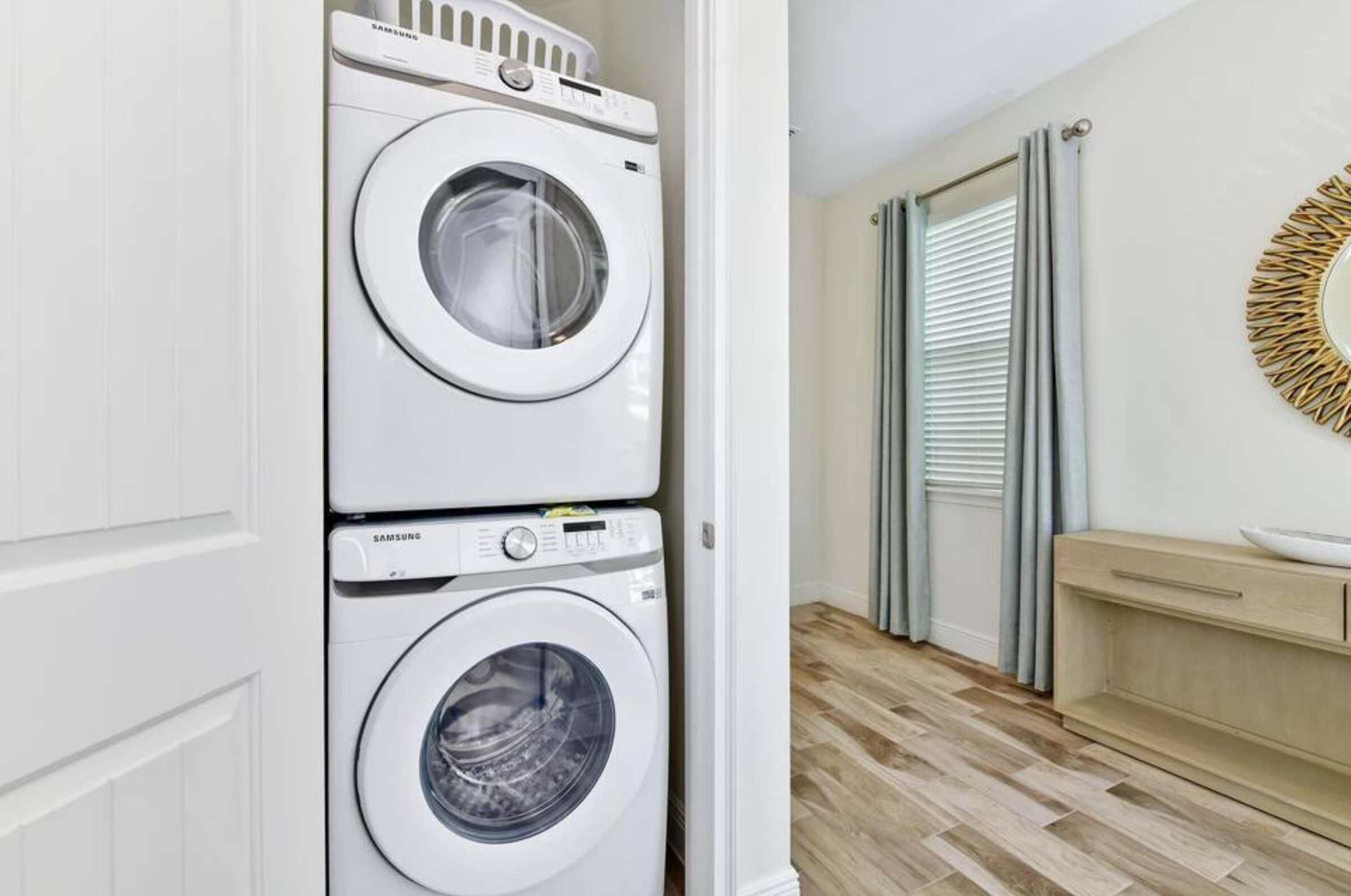 A laundry room with two stacked white Samsung washing machines.