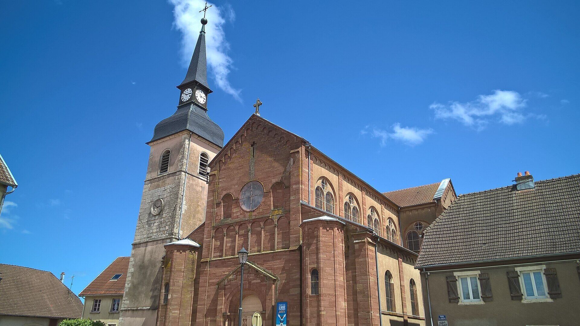Une église historique, dotée d’un clocher et d’une tour de l’horloge imposants, avec des fenêtres en arc et une façade traditionnelle en briques.