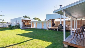A modern outdoor patio area with a wooden deck, a barbecue grill, and a seating area with chairs and tables. - South Cantina * Currarong π€πΌππ½π¨βπ©βπ§βπ§ππ©²οΏ½ (Currarong)