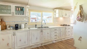 A kitchen with white cabinets, a sink, a window, and a stove. - South Cantina * Currarong π€πΌππ½π¨βπ©βπ§βπ§ππ©²οΏ½ (Currarong)
