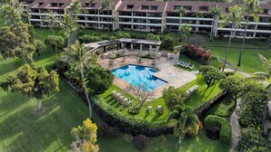A resort with a central pool, lush landscaping, and multiple buildings with a uniform architectural style. - NEW LISTING: Ka’anapali Royal K303 2BR – Ocean Views, Pool, Walk to Golf & Beach (Lahaina)