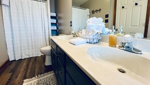 A bathroom with a large sink, a toilet, and a shower curtain. - Spacious Home •Pet Friendly •Mtn Views & Firepit! (Sevierville)