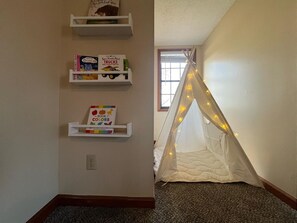 A room with a bookshelf, a window with curtains, and a white tent with lights. - Spacious Home •Pet Friendly •Mtn Views & Firepit! (Sevierville)