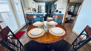 A dining area with a round table set for four, surrounded by chairs. - Spacious Home •Pet Friendly •Mtn Views & Firepit! (Sevierville)