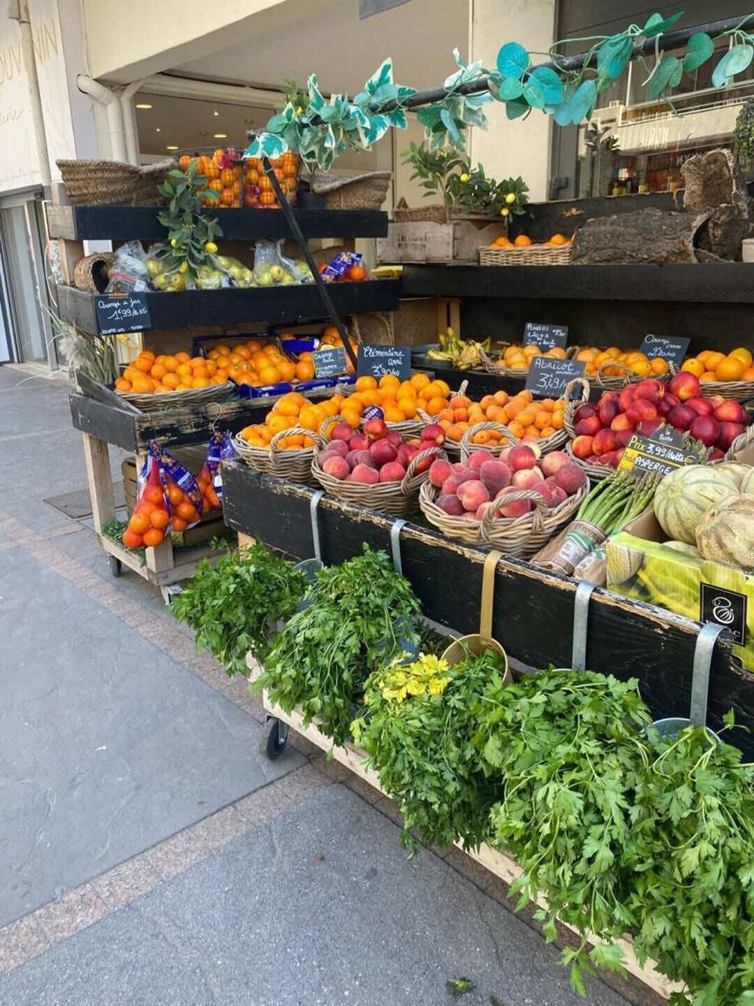 Ein Gemüse- und Obststand mit einer Vielfalt an Produkten, präsentiert in Körben und Kisten.