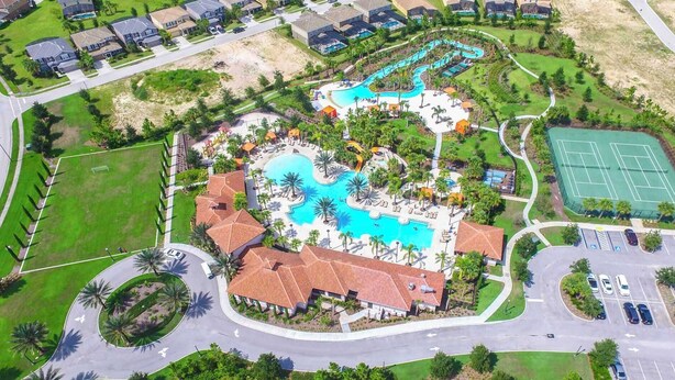 An aerial view of a resort with a large central pool, multiple smaller pools, a tennis court, and a parking area. - Sun-soaked At Solterra (Davenport)