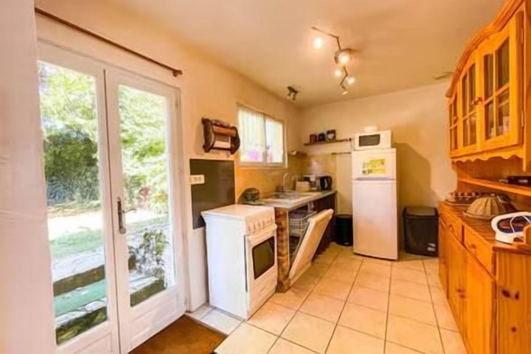 A compact kitchen with a stove, microwave, and cabinets.