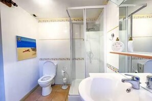 Un baño con inodoro, ducha y lavamanos.