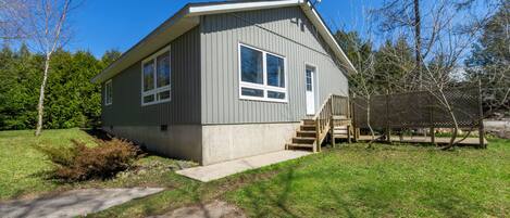A single-story house with a front porch, a satellite dish, and a small deck.
