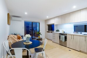 A modern kitchen with wooden cabinets, a built-in oven, and a large window.