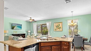 A kitchen with a granite countertop, stainless steel appliances, and wooden cabinets. - The Magic Hideaway at Solterra (Davenport)