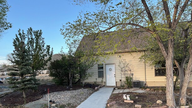 A residential house with a front yard, a pathway, and a small garden area. - Charming farmhouse in Price (Price)