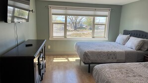A bedroom with two beds, a dresser, a window with blinds, and a ceiling light. - Charming farmhouse in Price (Price)