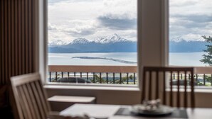Una habitación con vistas a un lago y montañas.
