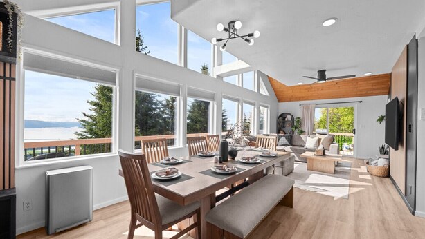 Un amplio salón con una gran mesa de comedor, asientos cómodos y vistas al exterior.