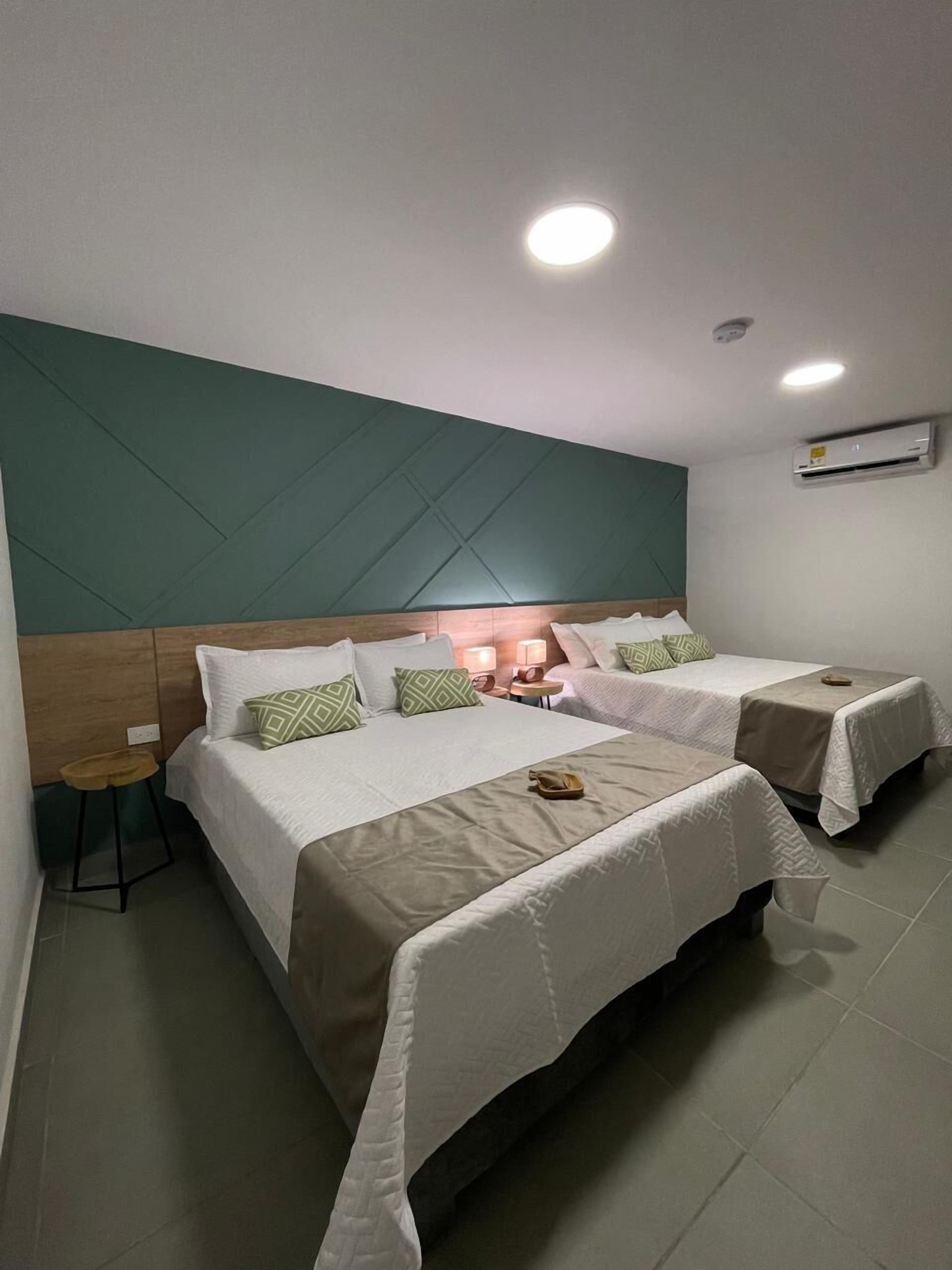 Habitación cuádruple, 2 camas dobles | 1 dormitorio, caja fuerte, escritorio y cortinas opacas