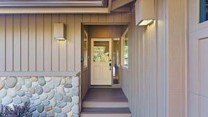 A house with a stone foundation, a wooden front door, and a set of steps leading to the entrance. - 6 Dutchman - Light, Bright, Lovely, Enclosed Deck, Hot Tub, SHARC (Bend)