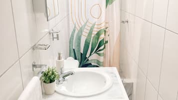 Een douche, handdoeken, zeep, toiletpapier