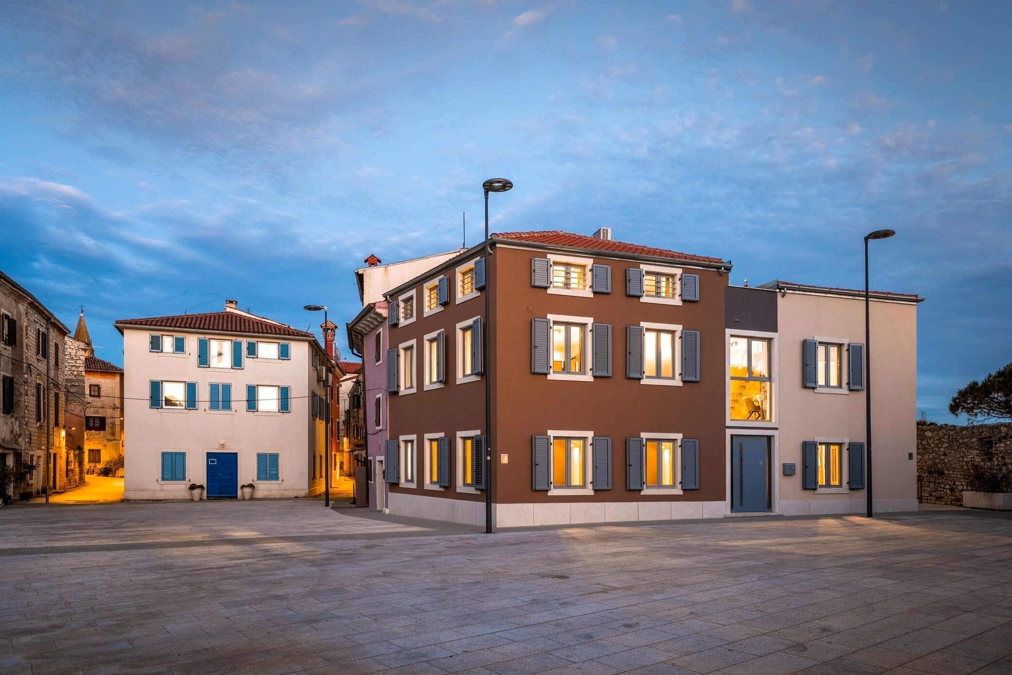 Ein modernes Gebäude mit zahlreichen Fenstern und Türen, das verschiedene Architekturstile vereint.