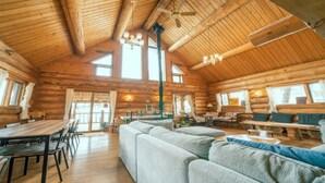 A log cabin interior with a dining area, a sofa, and a fireplace. - Madarao Vacances Village (Myoko)