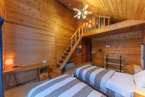 A wooden cabin room with two beds, a ceiling fan, a staircase, and a heater. - Madarao Vacances Village (Myoko)