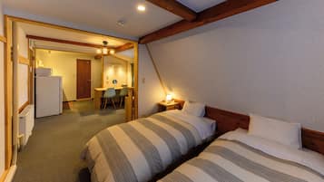 Une chambre d’hôtel avec deux lits, une kitchenette, un coin repas et une salle de bain.